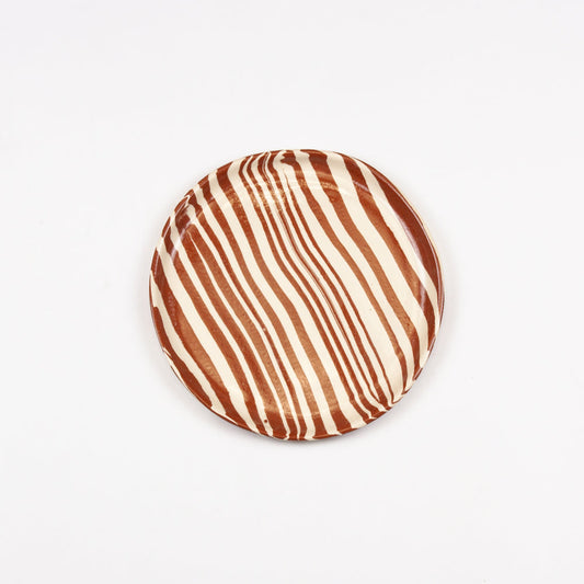 Round cushion with brown and beige striped pattern on a white background